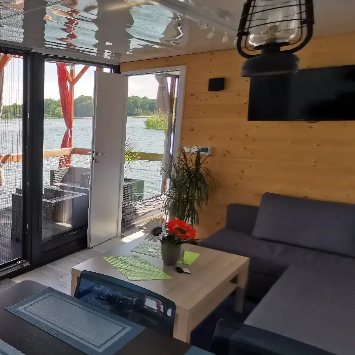 Intérieur de la cabane flottante au Lac du Der avec vue sur l’eau et terrasse